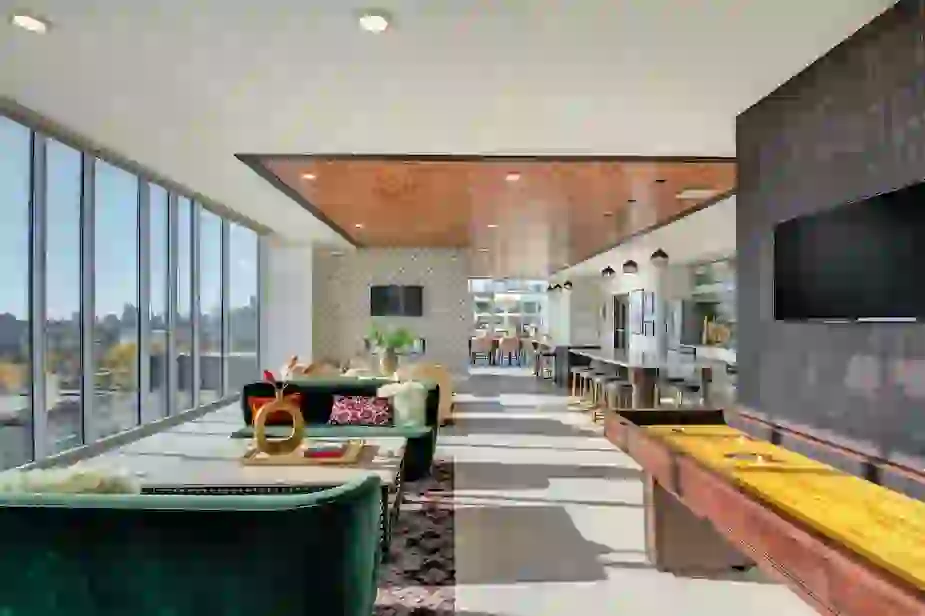 Resident Lounge with wall of windows showing a view of the Prospect Park neighborhood