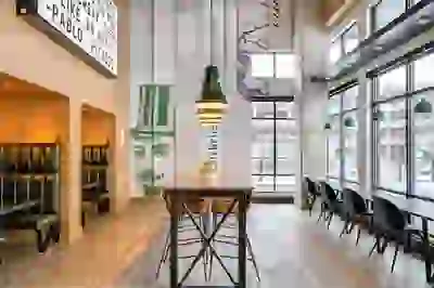 Open lounge space with high ceilings, private booths, and bar-height dining